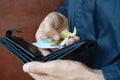 A male hands with coins with small Ukrainian bills and black old purse