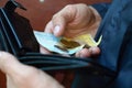 A male hands with coins with small Ukrainian bills and black old purse