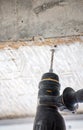 Male hands of construction worker drills hole in concrete with hand drill. the process of drilling holes in concrete beams and