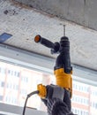 Male hands of construction worker drills hole in concrete with hand drill. the process of drilling holes in concrete beams and