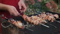Male hands cooking shish kebab grilling on skewers outdoors. BBQ, food on grill.