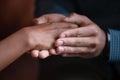 Male hands covering palm of mixed race female expressing care