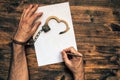 Male hands cuffed signing confession, top view