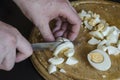 Male hands cut boiled chicken eggs on a wooden chopping board Royalty Free Stock Photo