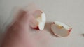 Male hands cut a half of an apple into pieces and clean the middle of pits. A man bisect red apple into two parts with a kitchen k