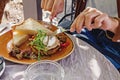 Male hands cutting poached egg with fork and knife. Royalty Free Stock Photo