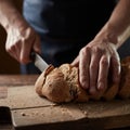 Male hands cutting wheaten bread, closeup