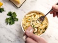 Male hands eating pasta with parsley with fork and spoon Royalty Free Stock Photo
