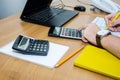 Male hands fill out tax forms 1040 on the background of a calculator and laptop. Office concept.