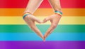 Male hands with gay pride wristbands showing heart Royalty Free Stock Photo