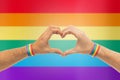 Male hands with gay pride wristbands showing heart Royalty Free Stock Photo