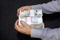 Male hands grabbed a large sum of money. Anonymous businessman reaching out hand to grab money, Russian ruble currency, in dark