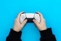 A male hands hold a gamepad on a blue background, top view. Royalty Free Stock Photo