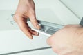 Male hands hold and insert metal screw to fix rail, assembling drawer of white dresser or wardrobe Royalty Free Stock Photo