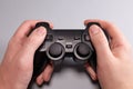 Male hands hold a joystick, gamepad, playing video games on a gray background Royalty Free Stock Photo