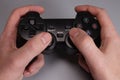 Male hands hold a joystick, gamepad, playing video games on a gray background Royalty Free Stock Photo