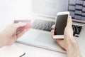 Male hands hold a phone and a bank card in front of a laptop monitor. Online earnings during the coronavirus pandemic. Close-up. Royalty Free Stock Photo