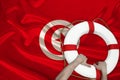 Male hands hold on a white life buoy against the backdrop of the silk national flag of the country of Tunisia, the concept of