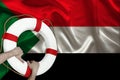 Male hands hold on a white lifebuoy against the background of the silk national flag of Sudan, the concept of medical insurance,