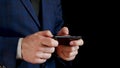 Male hands holding a black smartphone close-up. Fingers touch the touchscreen of the phone while typing. Businessman Royalty Free Stock Photo