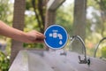 Male hands holding a blue faucet sign with the tap water faucet in the park Royalty Free Stock Photo