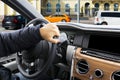 Male hands holding car steering wheel. Hands on steering wheel of a car driving. Young Man driving a car inside cabin. Multimedia