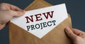 Male hands holding craft envelope with text NEW PROJECT on blue background Royalty Free Stock Photo