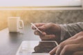 Male hands holding credit card and using Tablet with a cup of coffee on the table. Online shopping concept.. Royalty Free Stock Photo