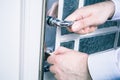 Male Hands Holding Door Handle And Locking The Door With A Key, Prevent Burglary Concept