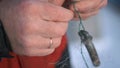 Male hands holding a fishing hook.Clip. A view of strong male hands holding a hook designed for fishing on which there Royalty Free Stock Photo