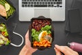 Male hands holding food delivery box eating lunch at work in office, flat lay.