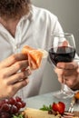 male hands holding ham, prosciutto, jamon salami with red wine. Antipasto Dinner or aperitivo party concept Royalty Free Stock Photo