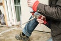 Male hands are holding an old professional gun for aerosol insulating foam, with a balloon and checking its work.