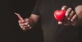 Male hands holding red heart on smartphone