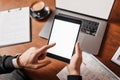 Male hands holding tablet with blank background at workplace. Businessman working at desk with documents Royalty Free Stock Photo