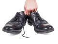 Male hands holding up a pair of worn black leather shoes Royalty Free Stock Photo