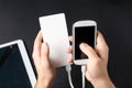 Male hands holding a white cellphone connected to a power bank Royalty Free Stock Photo