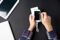 Male hands holding a white cellphone connected to a power bank Royalty Free Stock Photo