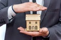 Male hands holding wooden house model close up Royalty Free Stock Photo