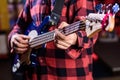 Male hands holds bass guitar, play music in club atmosphere background. Musician, artist play electric guitar musical Royalty Free Stock Photo