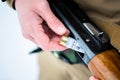 male hands hunter inserted cartridge 12 caliber rifle on a background of pine forest in winter Royalty Free Stock Photo