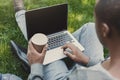 Male hands with laptop and coffee closeup,over shoulder shot outdoors