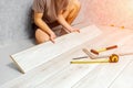 male hands is laying wooden panel of laminate floor indoors.