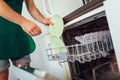 Male hands loading dirty dishes to the dish washing machine