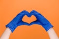 Male hands in medical protection latex gloves making heart symbol as a way to show thank gratitude to doctors and nurses for help