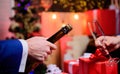 Male hands opening champagne bottle pouring glasses christmas decorations background. Drink champagne or sparkling wine