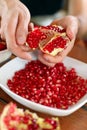 Male hands peeling pomegranate fruit