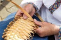 Male hands plaiting bast shoe.