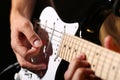 Male hands playing electric guitar with plectrum closeup Royalty Free Stock Photo