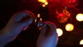 Male hands playing kartalas, candles and incense on a dark background